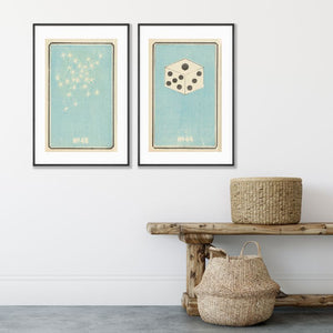 pale blue and white vintage art posters of die and fireworks hanging on wall above bench