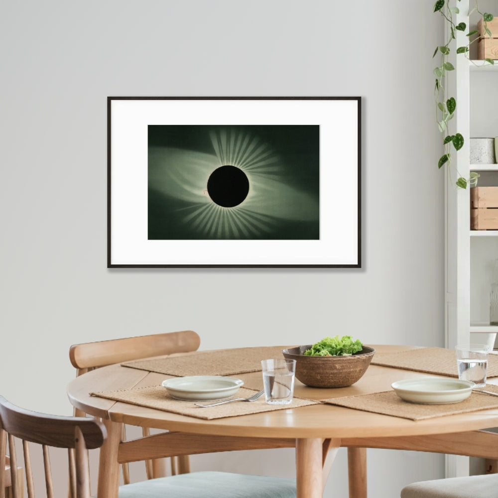 art poster of vintage solar eclipse lithograph hanging on wall above round kitchen table