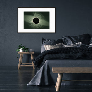 art poster of vintage solar eclipse lithograph hanging on black wall in dark bedroom